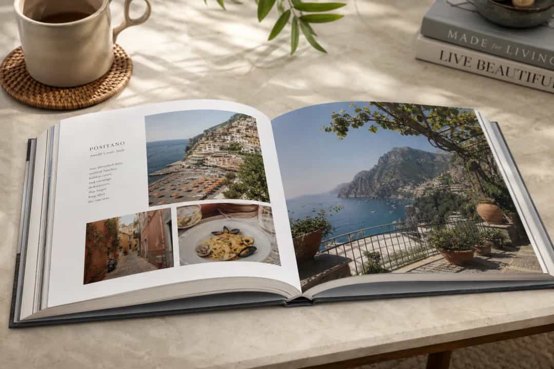 A cozy premium travel photo book open on a coffee table showing bright vacation memories