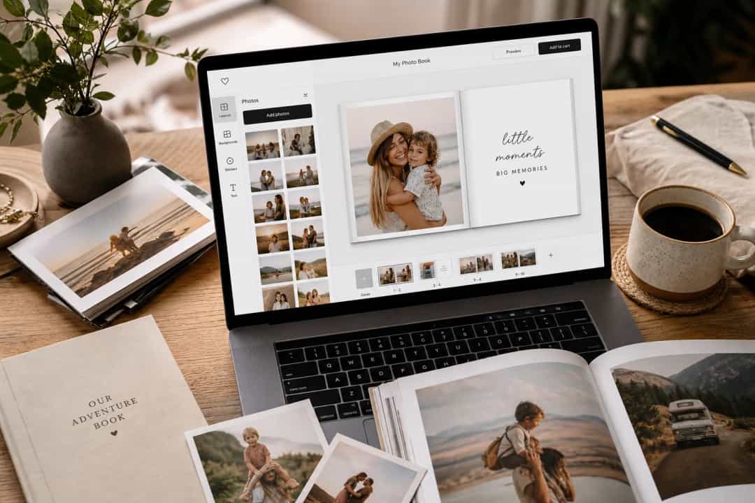 Personalisierte Fotoalbum, das online auf einem Laptop erstellt wird, mit gedruckten Fotos in der Nähe